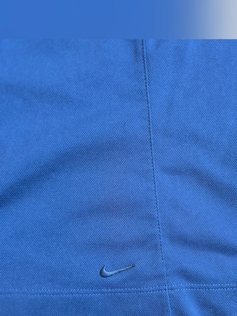 Royal blue sleeveless Nike Golf polo featuring a white-buttone